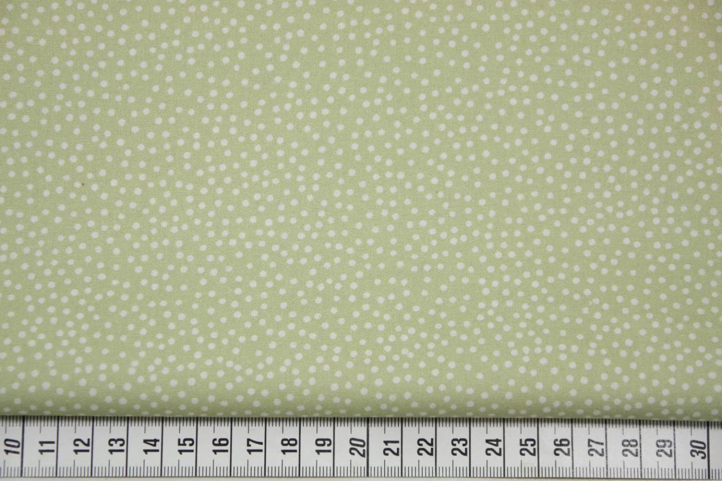 quiltstof-lichtgroen met ivoren stipjes.