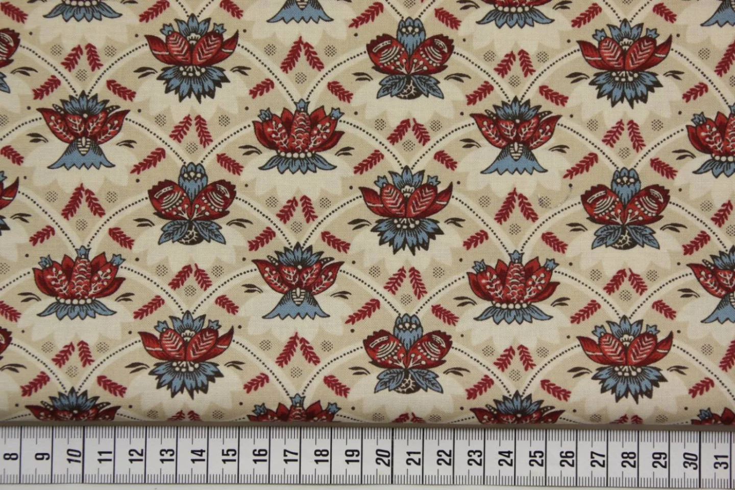 quiltstof-b -ivoor-rood met blauwe lelie.