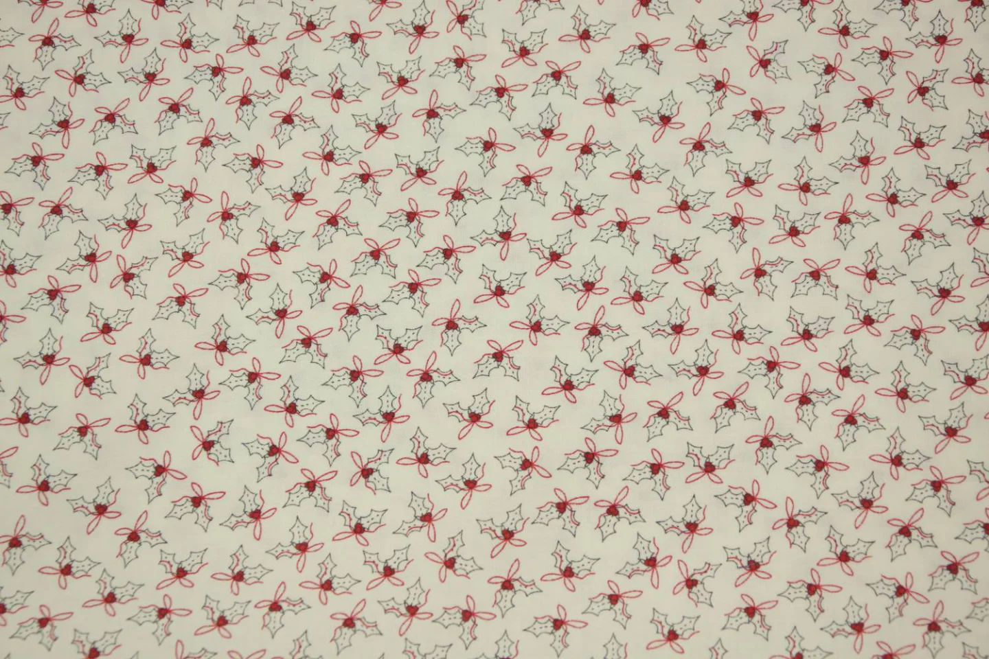 quiltstof-ivoor-hulstblaadjes in rood en.