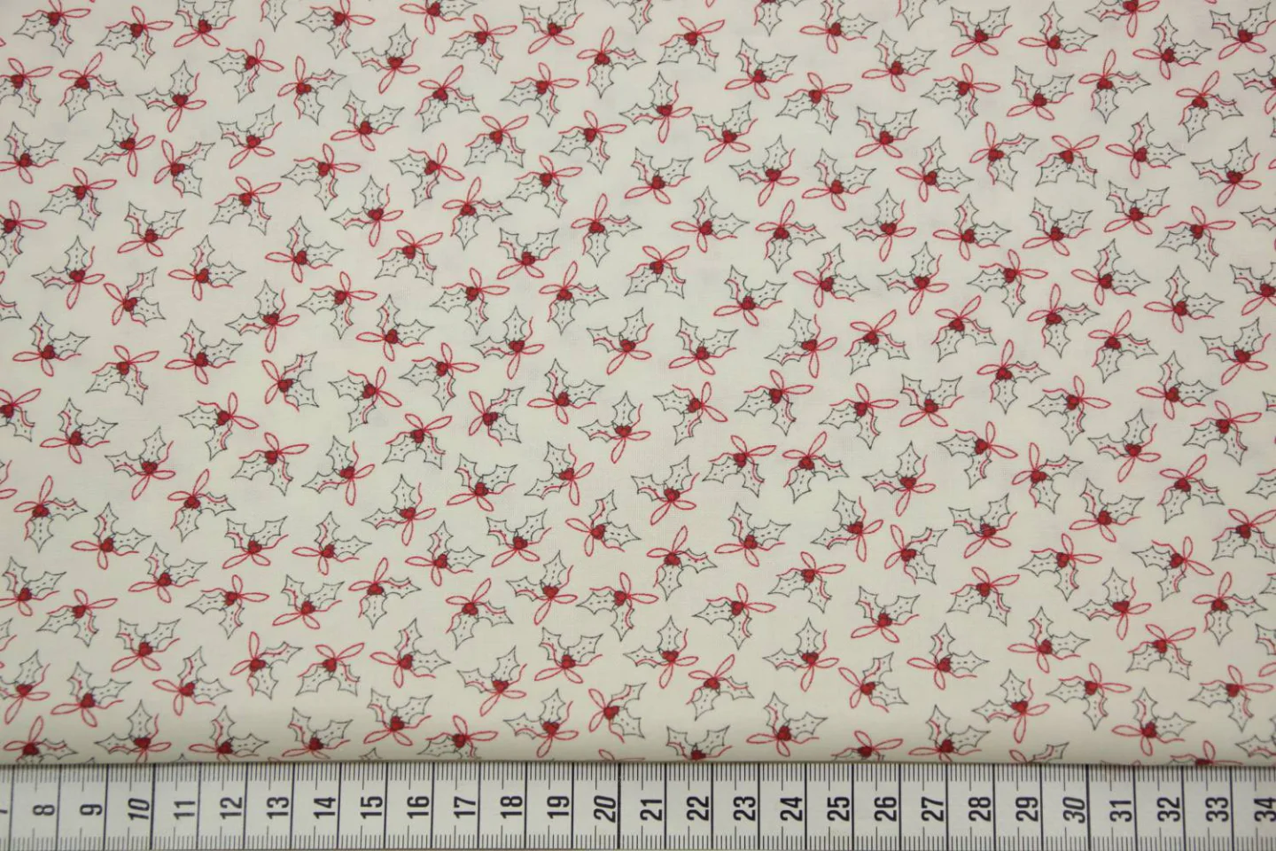 quiltstof-ivoor-hulstblaadjes in rood en.