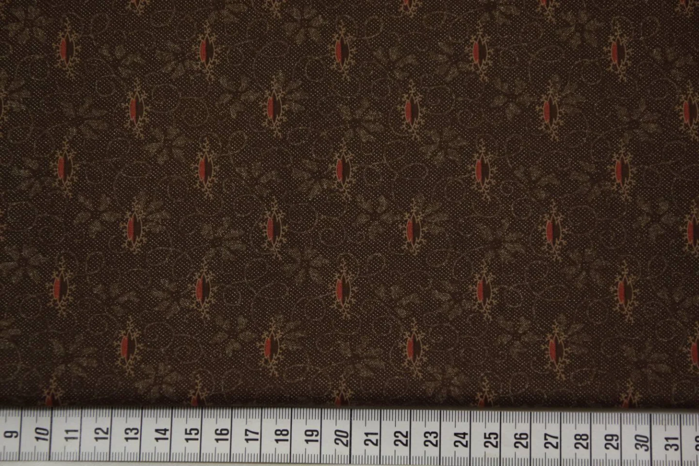 quiltstof bruin-motief in rood en beige-.