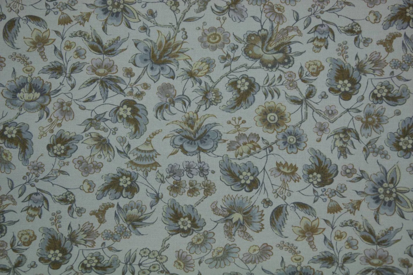 quiltstof-licht grijsblauw -bloemen aan.