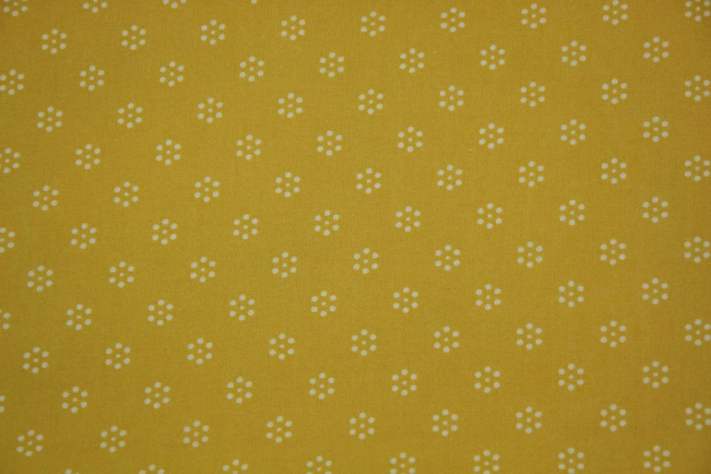 quiltstof-okergeel -stippen in bloemvorm.
