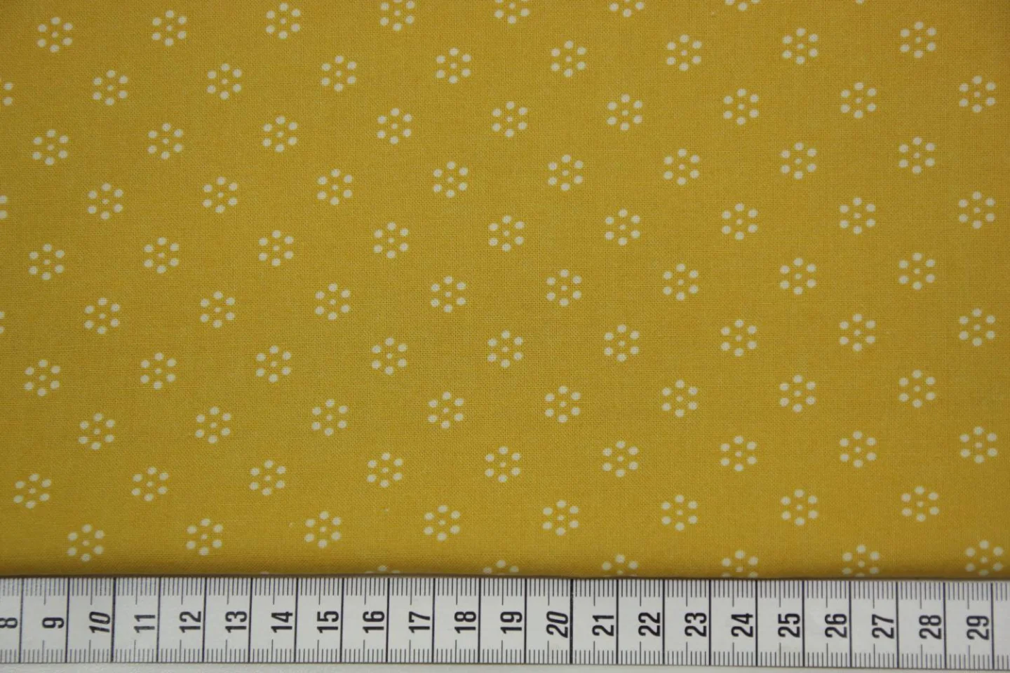 quiltstof-okergeel -stippen in bloemvorm.