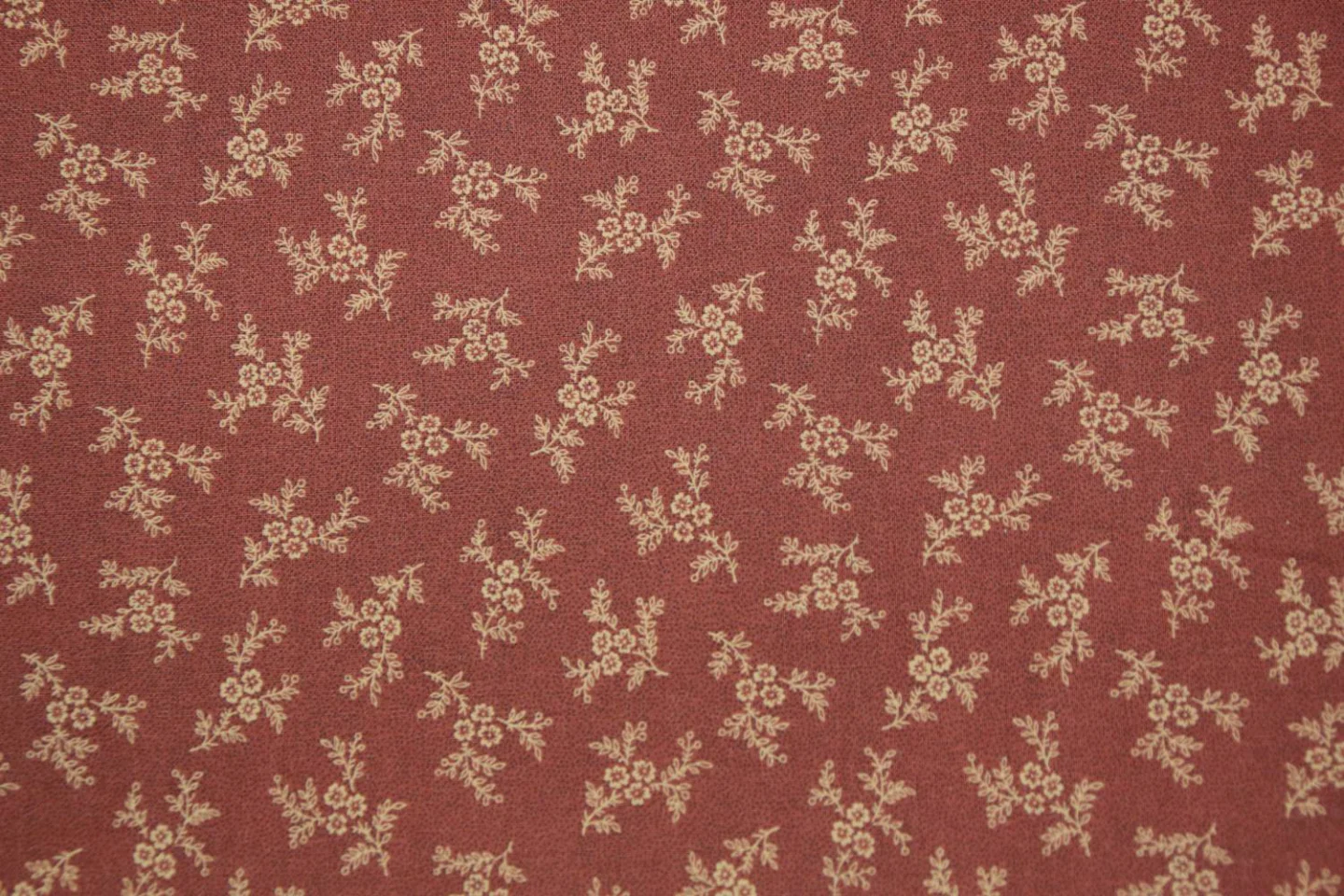 quiltstof-donker steenrood-ecru bloemtak.