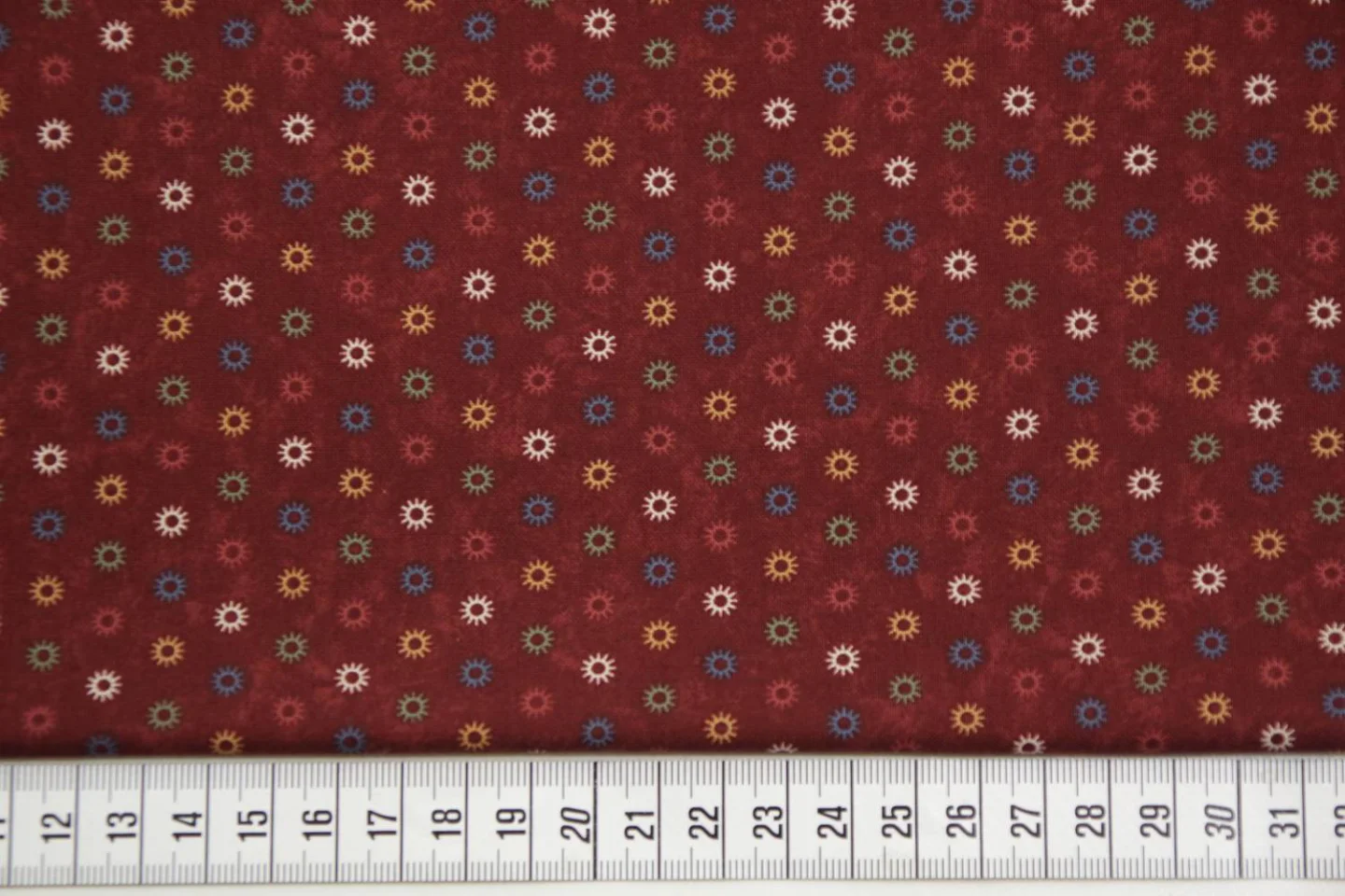 quiltstof-donkerrood met kleine zonnetje.