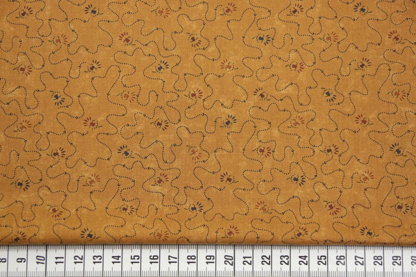 quiltstof-donker okergeel-blauwe stippel.