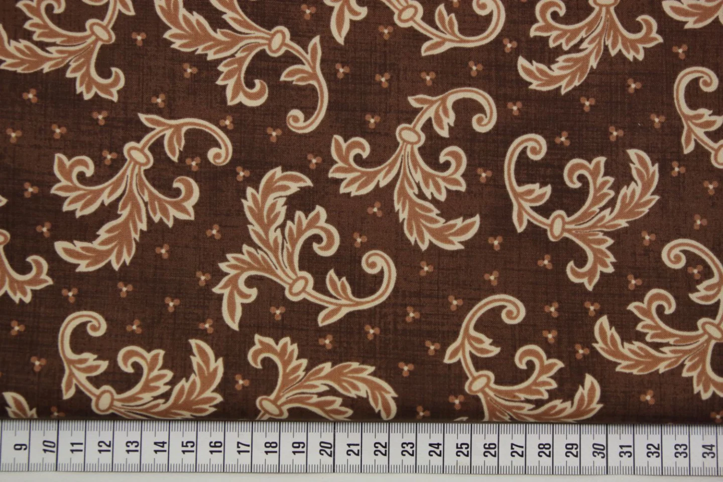 quiltstof-Warmbruin met bladtakken in ec.