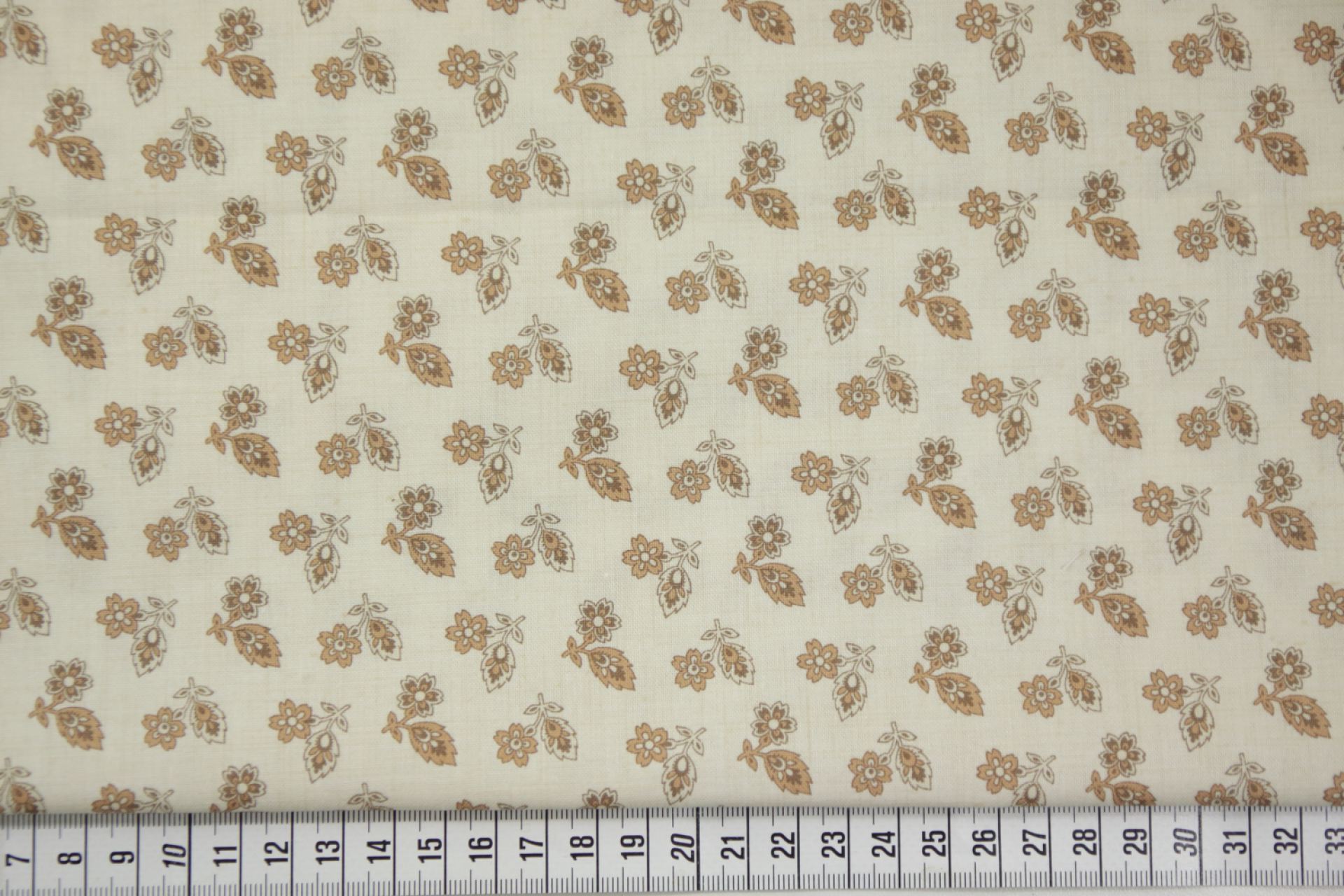 quiltstof-Ivoor met bloemtakjes in okerb